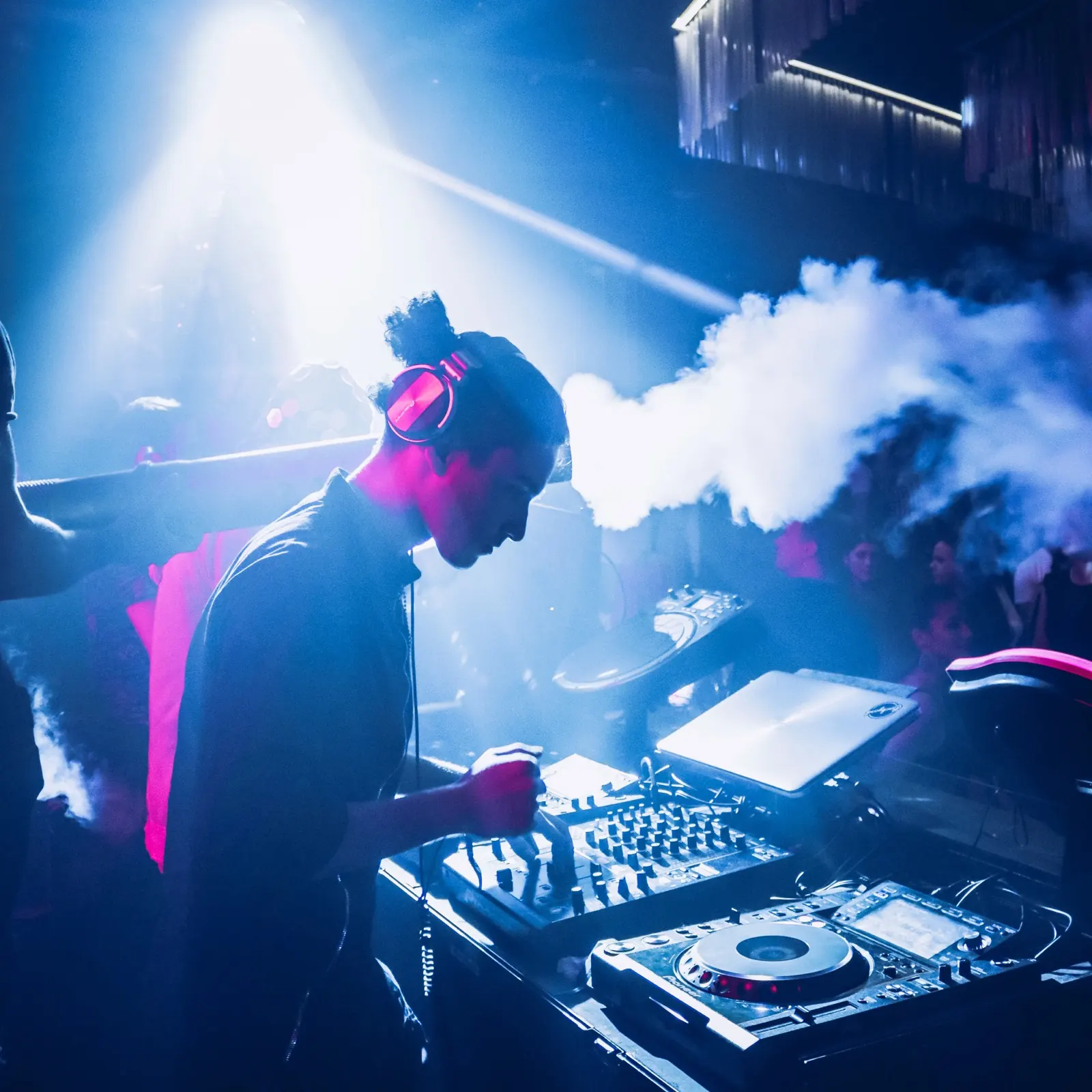 TAVI performing in a smoke-filled club under blue lights